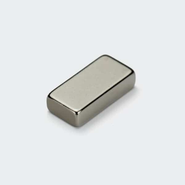 Rectangular shape strong magnet grade N35 with silver nickel plating surface treatment on a white desktop.