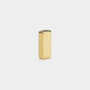 A shiny small neodymium block magnets with gold plating surface, vertically standing on a white background.