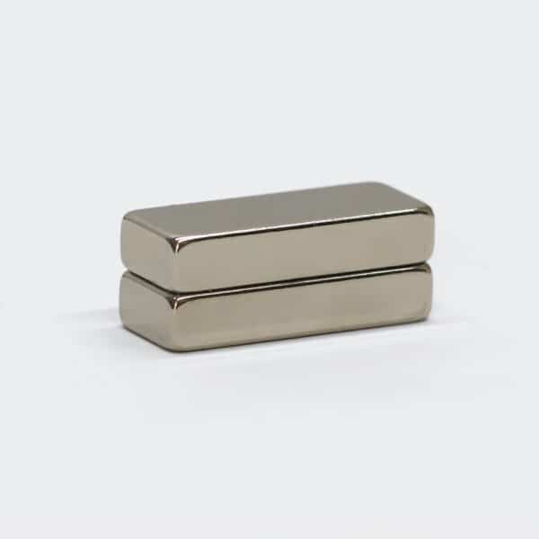 Two customized rectangular NdFeB magnets with silver nickel surface finishing, stacked together, laid flat.