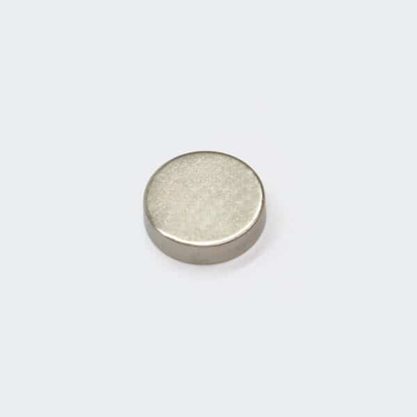 A small round NdFeB magnet with silver nickel plating surface treatment, laid flat on a white background.