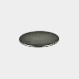 A thin round strong magnet with silver nickel plating, laid flat on a white desktop.